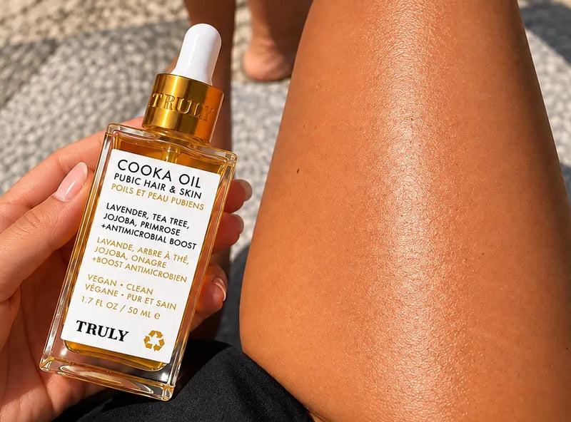 Frasco del aceite sobre la cama junto a la zona del bikini